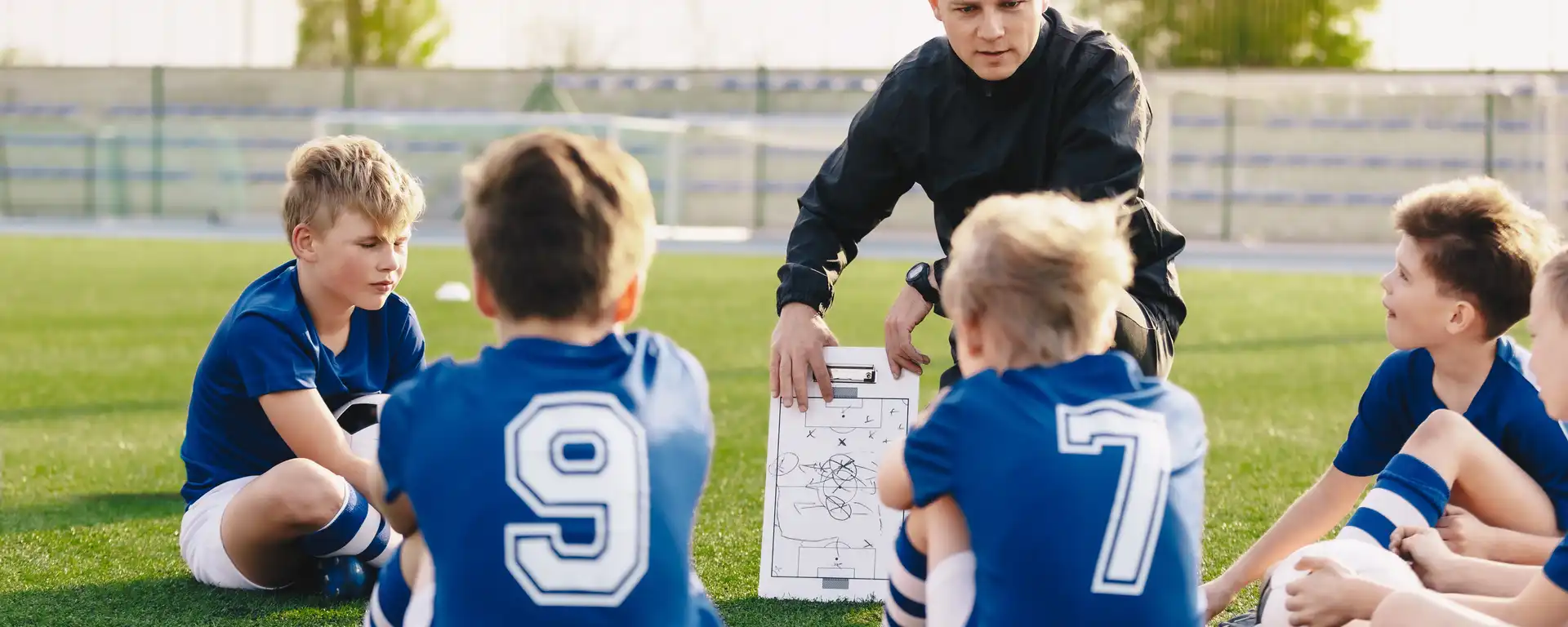 Ein Trainer, der mit einer jungen Fussballmannschaft spricht