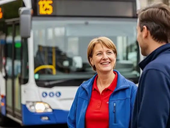 Eine lächelnde Frau in Nahaufnahme, im Hintergrund ein Bus.