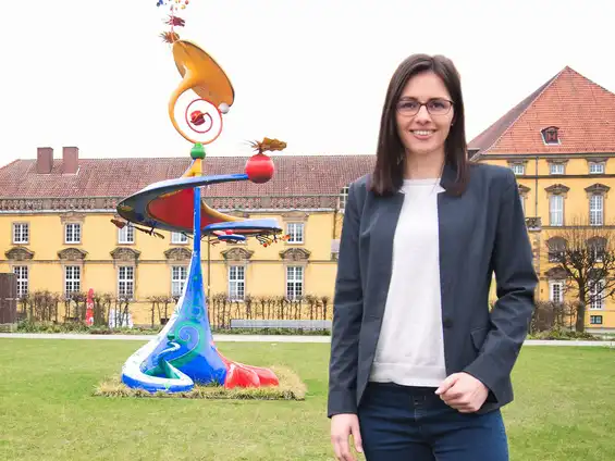 Kirstin Berger vor einem großen gelben Gebäude